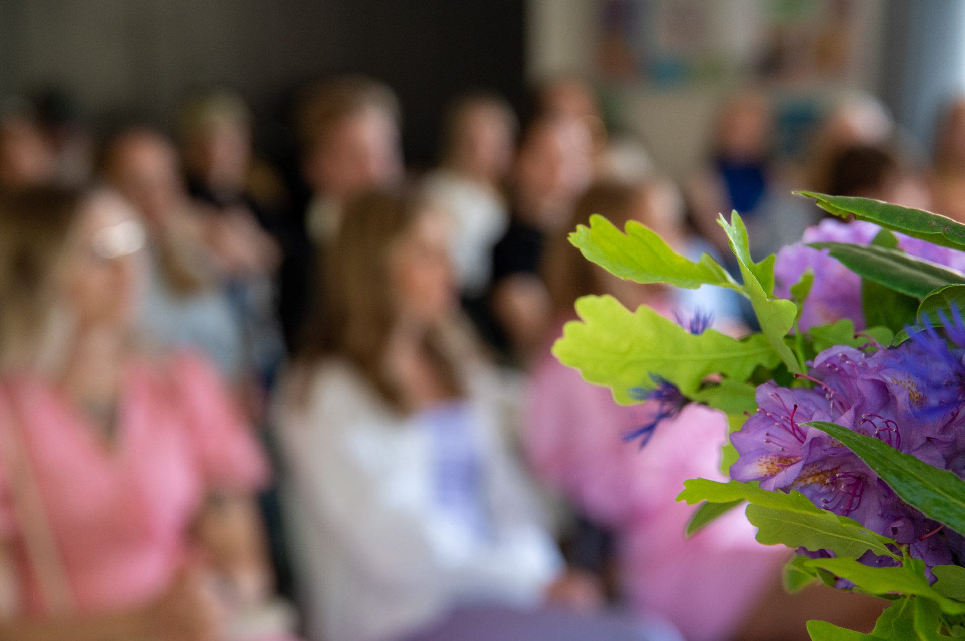 Blombukett i förgrunden och deltagare i bakgrunden